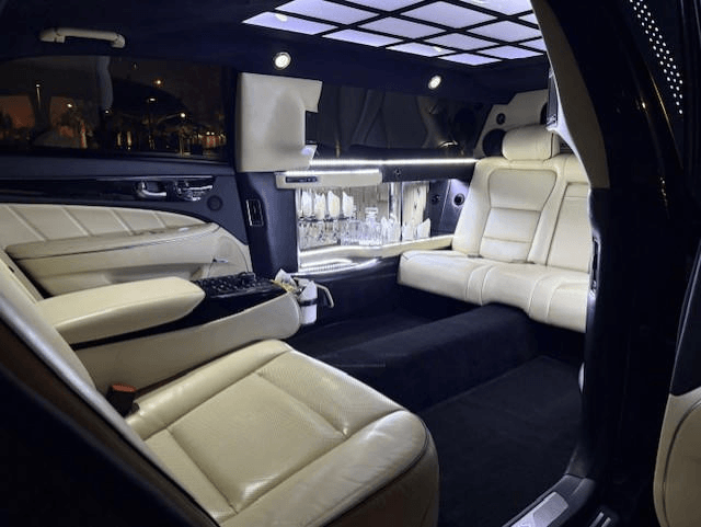 A white stretch limo waits under a resort porte-cochère.