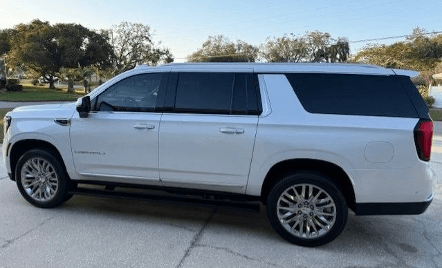 A white luxury SUV provides premium limousine services outdoors.