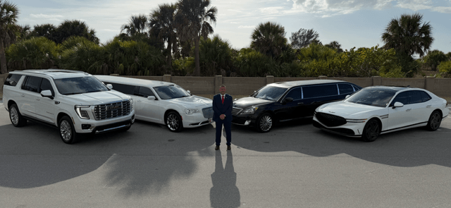 Man standing with luxury cars in background.